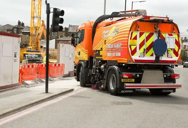 Operator performing safety checks on road sweeper before night shift